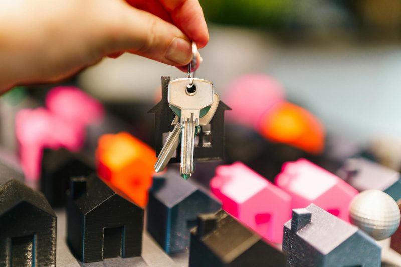 Colorful miniture houses and a hand holding keys